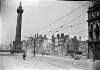 [O'Connell Street between Abbey Street, North Earl Street shell damaged, full view of Nelson's Pillar, lone motor cyclist, cars, crowds in distance]