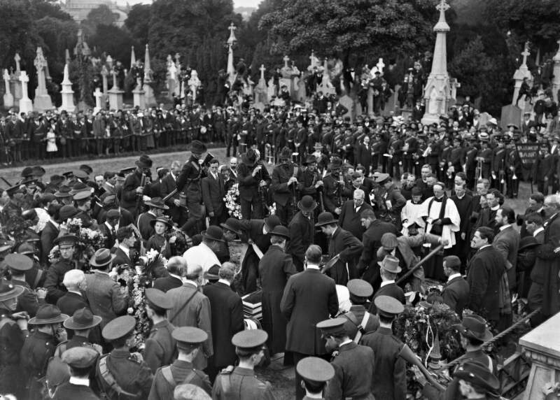 [Funeral of O'Donovan Rossa, Glasnevin Cemetery. Lowering of coffin into grave. Padraic Pearse putting papers in his jacket pocket]