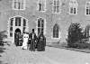 [George V, Queen Mary and clergy in front of one of Maynooth's buildings]