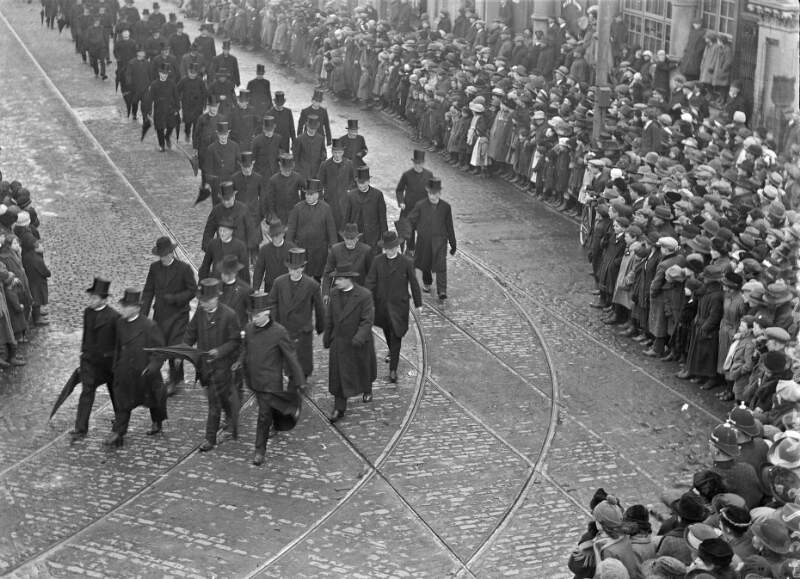[Funeral of Dr. Walsh, Archbishop of Dublin, procession of clergy through street, crowds look on]