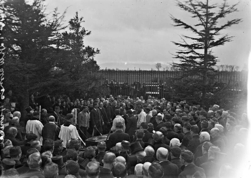 [Funeral of Dr. Walsh, Archbishop of Dublin, coffin being lowered into grave, in Glasnevin Cemetery, crowds]