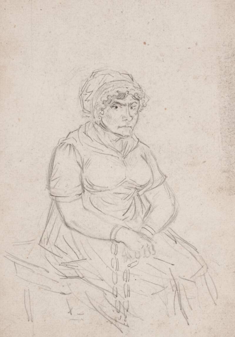 [A seated woman with her hands chained]