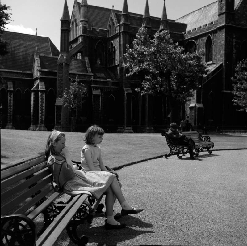 [Two girls on park bench, St. Patrick's Cathedral, Dublin]