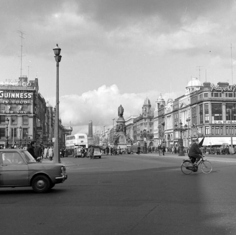 [View of O'Connell Street from bridge with O'Connell monument and half-demolished Nelson Pillar in distance]