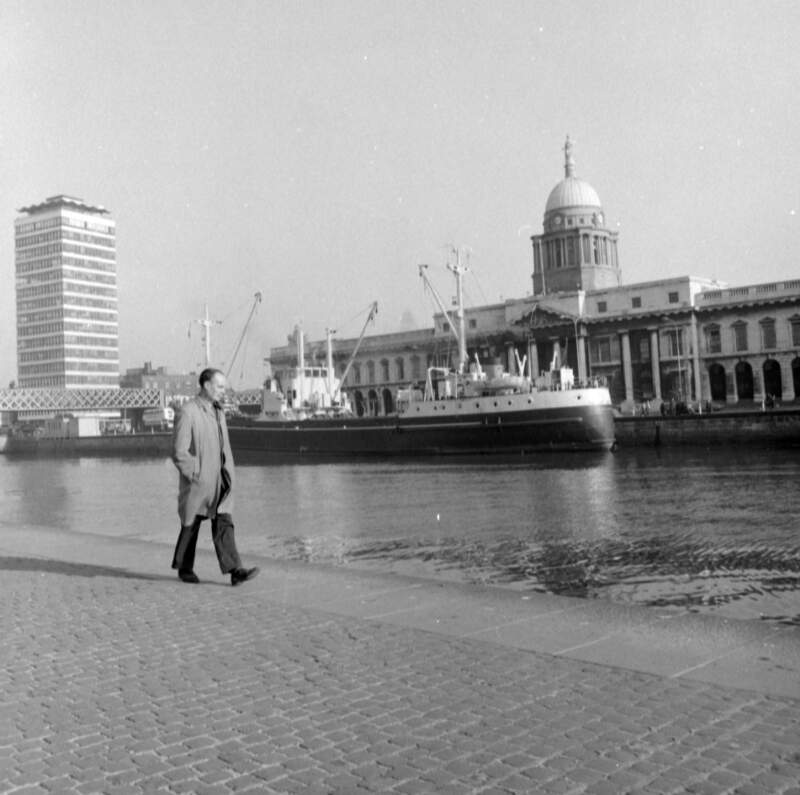 [Man walking on George's Quay with Custom House, Liberty Hall and ship in view, Dublin]