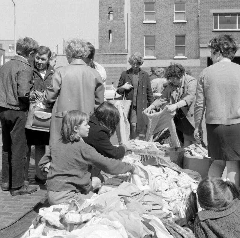 [Women and children rummaging through secondhand clothes, Cumberland Street market, Dublin]