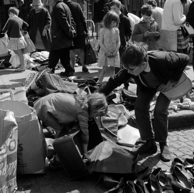 [Children playing with suitcase, shoppers in background, Cumberland Street Market, Dublin]