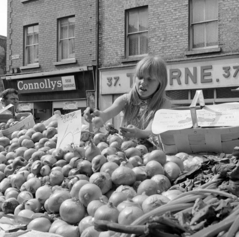 [Girl at vegetable stall, Moore Street Market, Dublin]