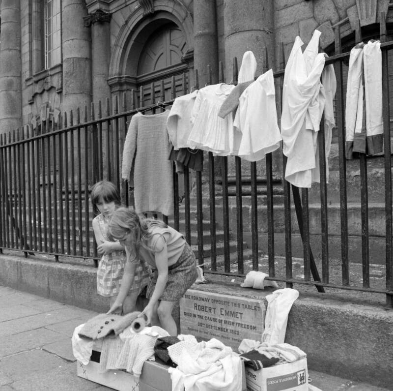 [Elizabeth (Lily) Collins and her friend Angela Arnold, sorting through secondhand clothes they are selling in aid of the charity Gorta, outside St. Catherine's Church, Thomas Street, Dublin]