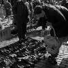 [Woman inspecting shoes, Cumberland Street Market, Dublin]