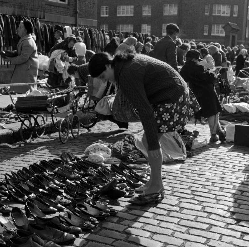 [Woman trying on secondhand shoes, Cumberland Street Market, Dublin]