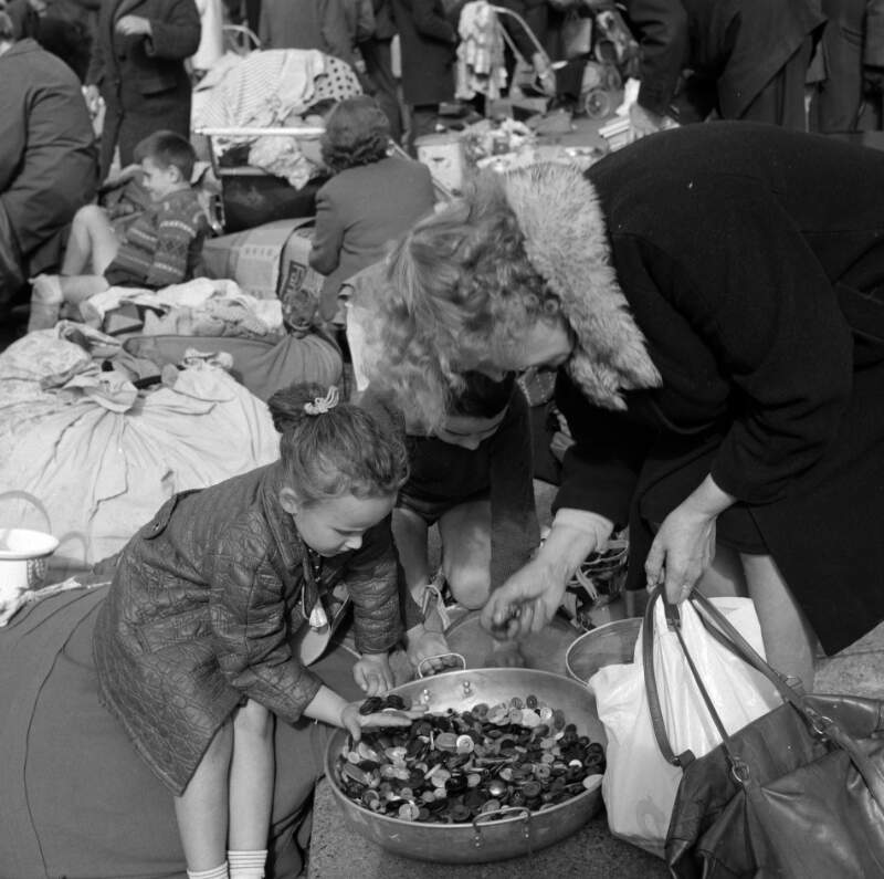 [Woman and little girl looking through bowl of buttons, Cumberland Street Market, Dublin]