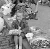 [Little girl, with handbag, sitting beside large bowl of buttons, Cumberland Street Market, Dublin]