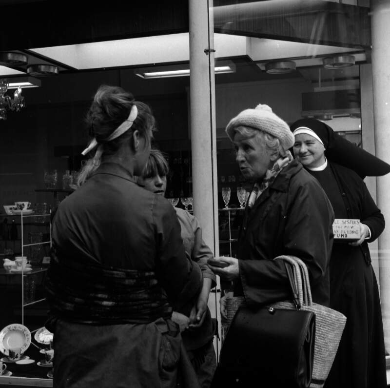[Nun collecting outside china showrooms, old woman in foreground, Grafton Street, Dublin]