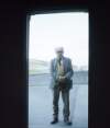[Patrick Kavanagh standing in church doorway, hills in background, Inniskeen, Co. Monaghan]