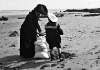 [A mother and her son Trevor, filling a bag with sand on a beach, Ireland]