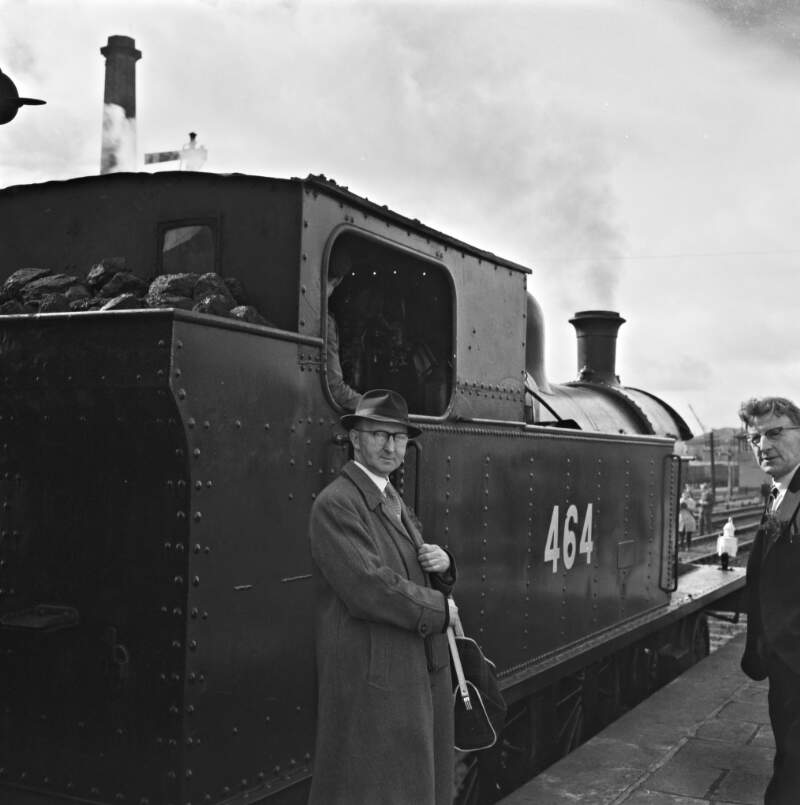 [Kevin Murray standing in front of a train numbered "464" with a railway foreman at Cork station, Co. Cork]