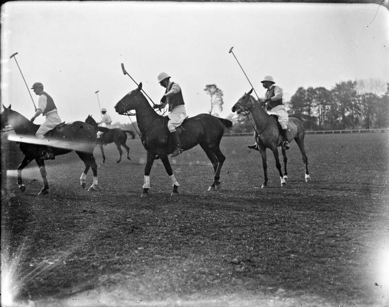 [Four polo-players riding horses and holding polo-sticks]