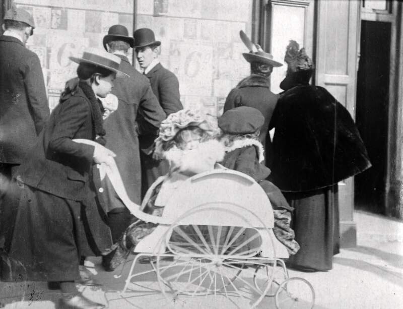[Young girl pushing two infants in a perambulator]