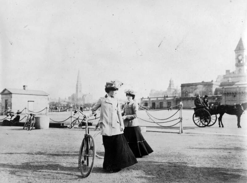 [Two ladies with bicycles at Kingstown]