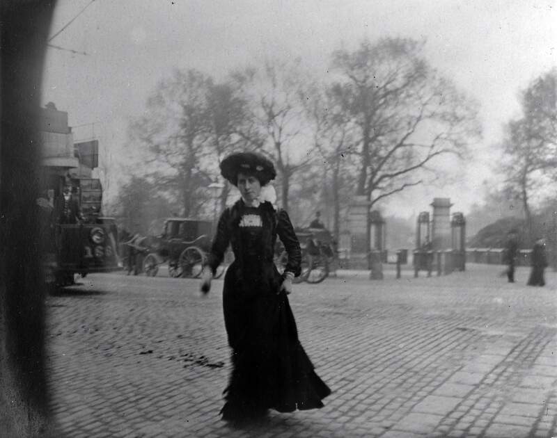[Women crossing the road, with gate to St. Stephen's Green in background]