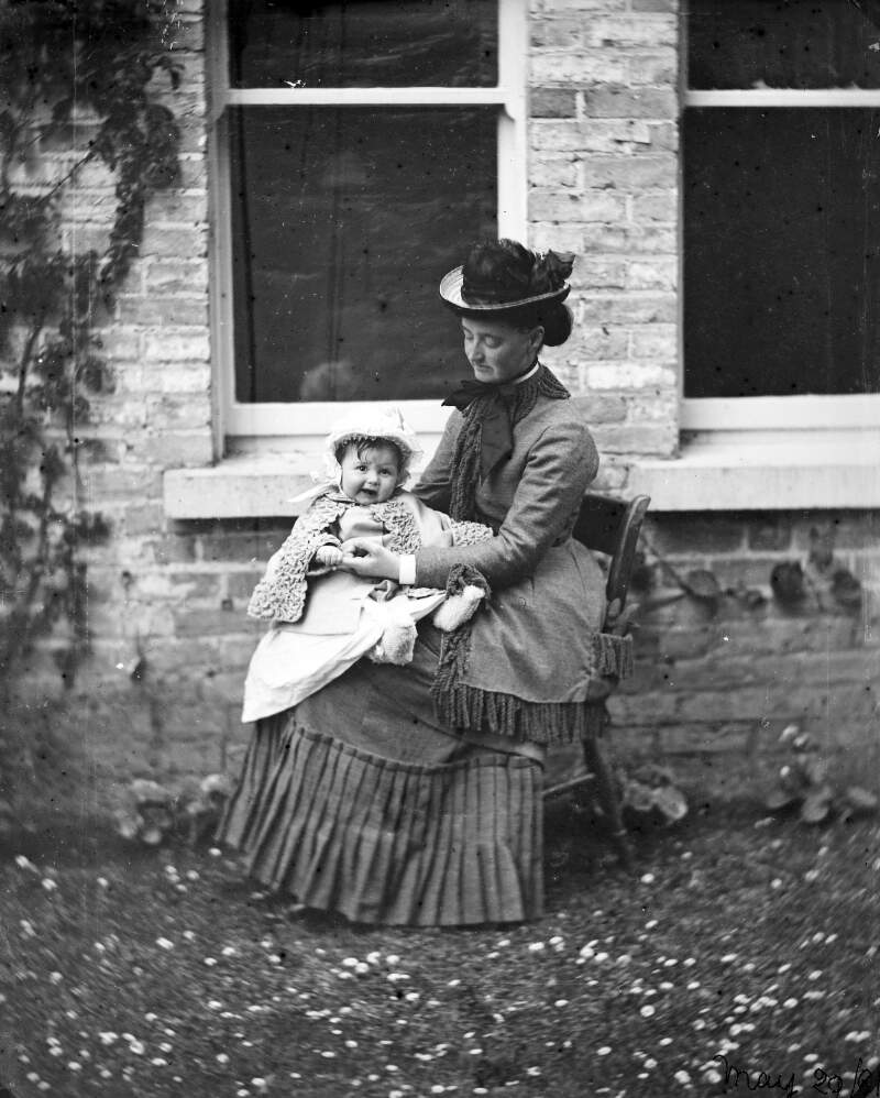 [Augusta Caroline Dillon seated outside the photograph house with baby on her knee, probably daughter Ethel]