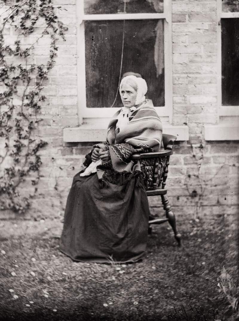 [Portrait of servant woman, known as widow kelly, seated outside the photograph house, Clonbrock, Co.Galway]