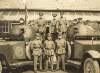 [Members of the National Army, including Major General Tom Ennis, standing beside two armoured cars]