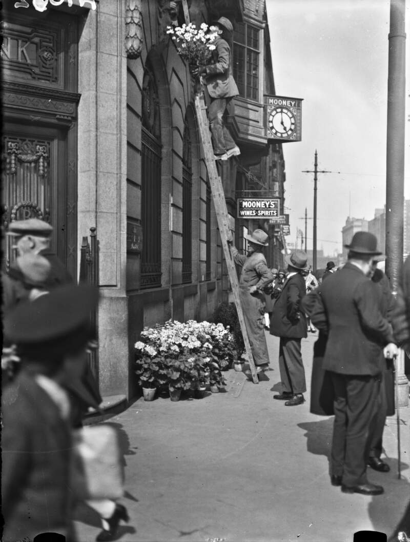 [Catholic Emancipation centenary celebrations. Man placing flowers on the Hibernian Bank building]