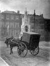 [Horse drawn carriage, with driver, parked alongside the National Monument, on the Grand Parade, Cork]