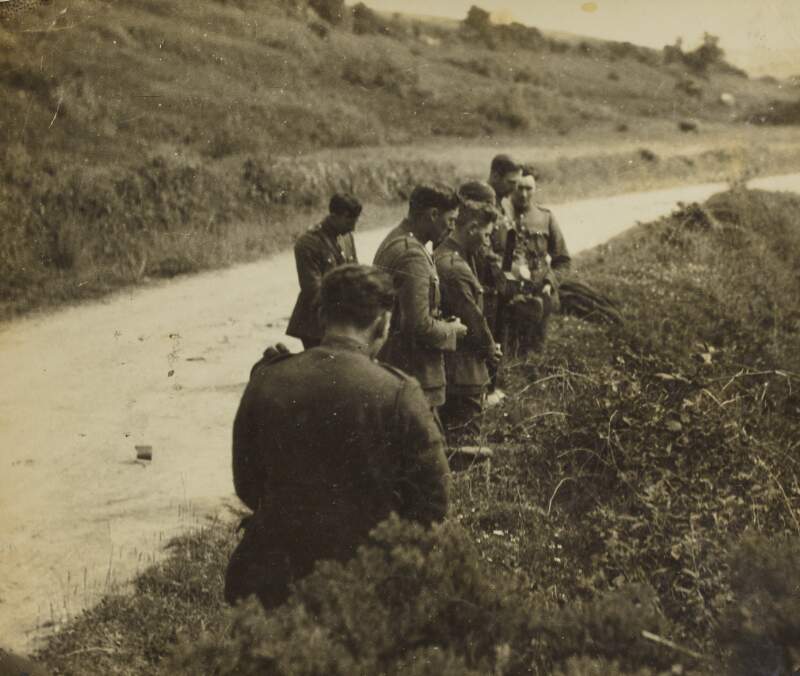 [Former comrades kneeling in prayer at the spot where Michael Collins was ambushed and killed, Cork]