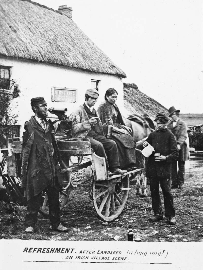 Published image:'An Irish Village'. Cart, man/woman; 2 men and boy serving beer outside, + sign 'Rich King Spirits'. Ragged attire.