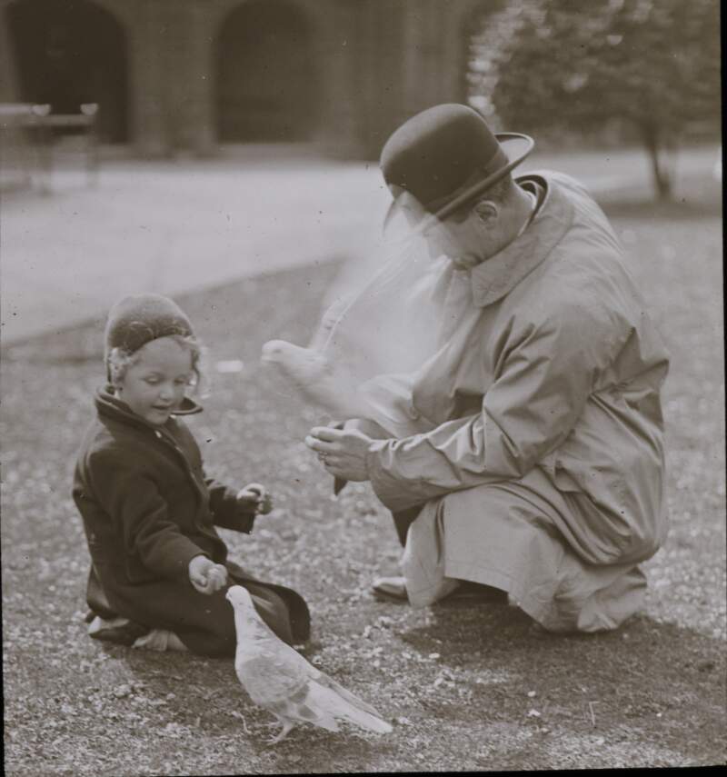 Man and child feeding birds.