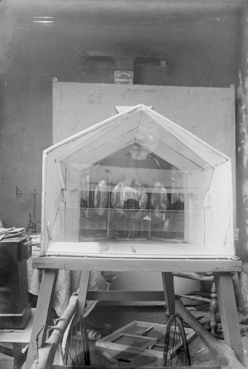 [Miniature house construction for butterflies, appears to be set on a wooden frame with wheels.]