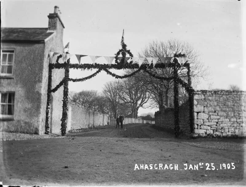 [Ahascragh, Jan 25, 1905] Arch decorated with flowers for wedding of Edith Dillon and Sir William Mahon, policeman/guard in distance.]