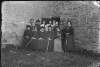 [Women's hockey team grouped at side of stone building. See Clon 102.]