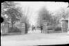 [Clonbrock/Keogh Gate. Carriage passing through gateway, man with top hat at front of carriage and man holding gate open.]