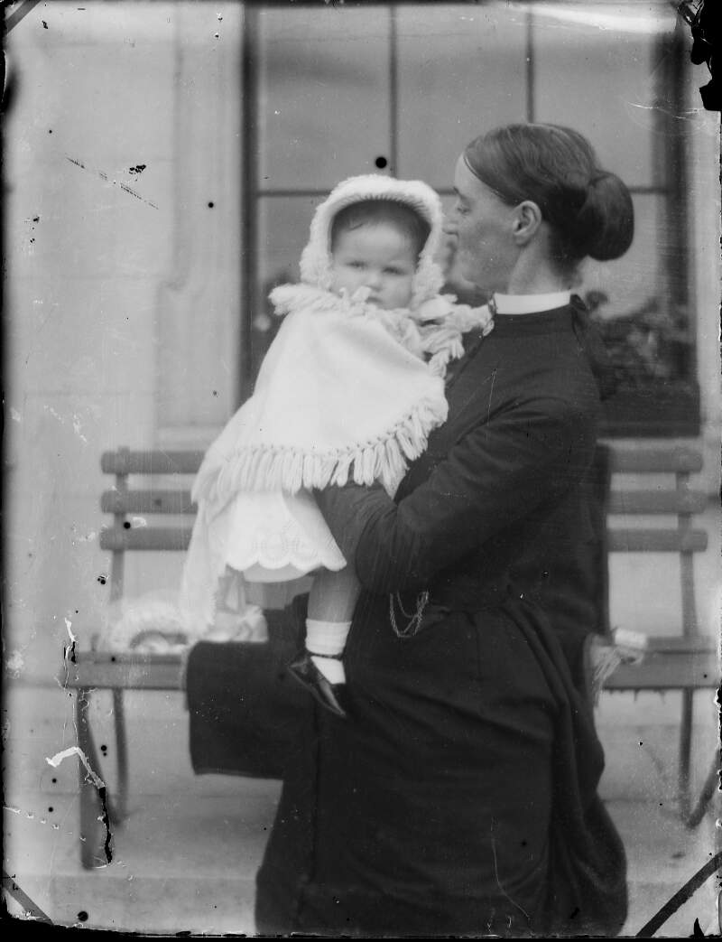 [Augusta Dillon holding child, child wearing bonnet, shawl and satin shoes.]
