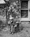 [June 18, 84. Young boy and girl outside photography house. Clonbrock boy seated wearing three piece suit.]