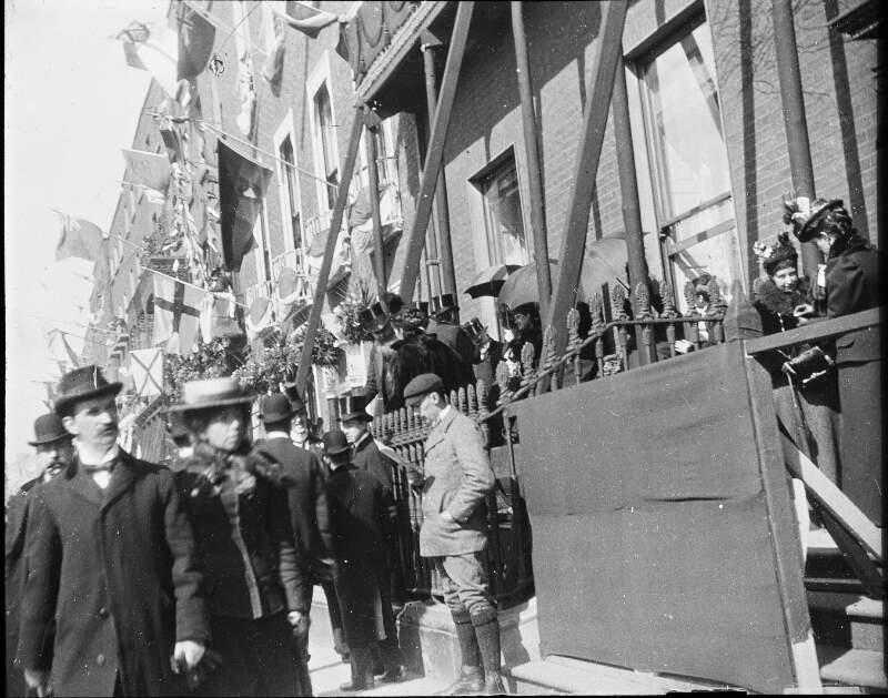 [Lord Ashbournes House. Crowd passing house on Merrion Square, decorated with bunting and flags. Occasion of Royal visit to Ireland 1900.]