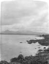 [Connemara E.L.D. Lake with mountain in distance, seaweed covered rocks in foreground.]