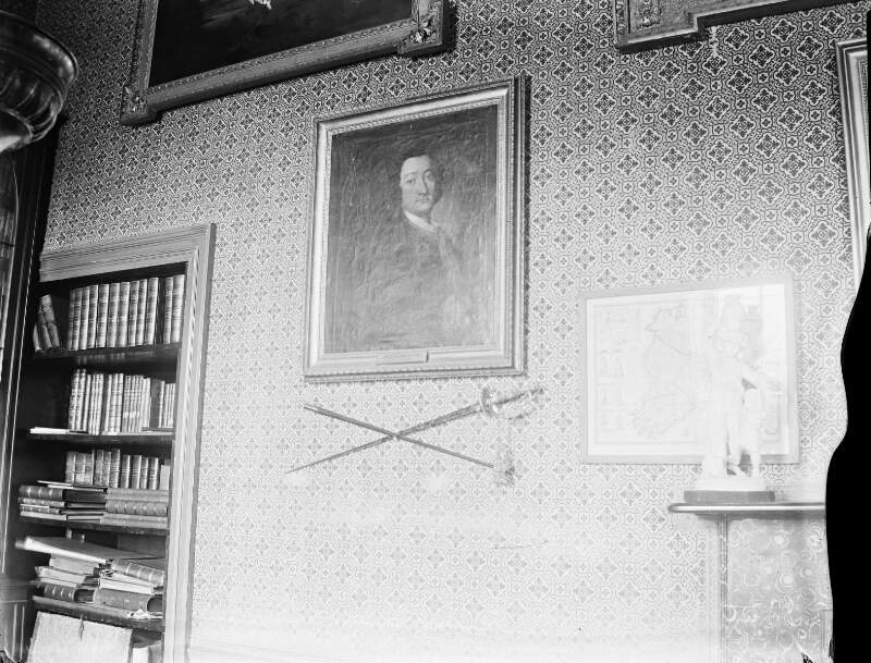 [Library pictures, Mote 1926. Framed pictures a pair of swords mounted on wall and bookcase.]