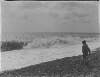 [Boxhill/Christ Church. Young boy on rocky beach with crashing waves.]