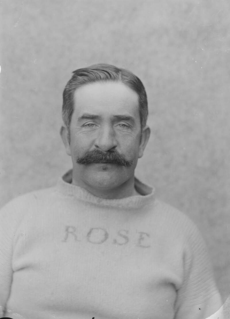 [Portrait of a man with moustache wearing a jumper embroided with the name "Rose".]