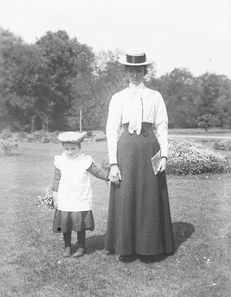 [Woman and a young child standing in a garden.]