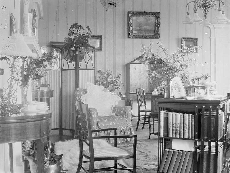 [Interior of drawing room with a lot of chairs and images on the walls. See Clon 2167. (Originally part of Mss. Box 46.7, subgroup 5, class f).]