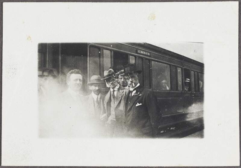 [Group of Sinn Féin organisers standing alongside a train, on their way Ennis, Co. Clare,