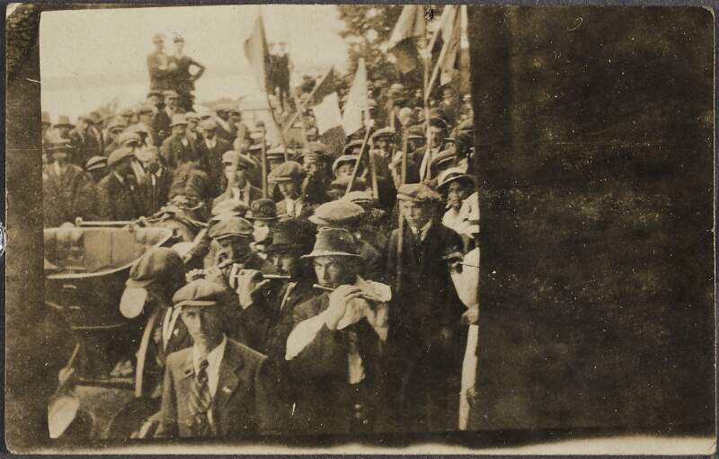 [Men with Irish flags and flutes, participating in a parade],
