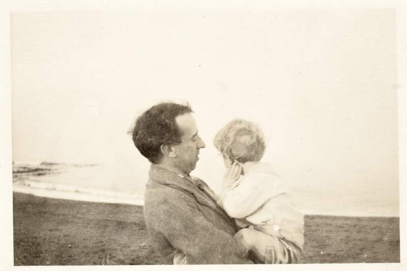 [Thomas MacDonagh on beach holding Donagh MacDonagh in his arms as Donagh gazes out to sea, at Greystones, County Wicklow]