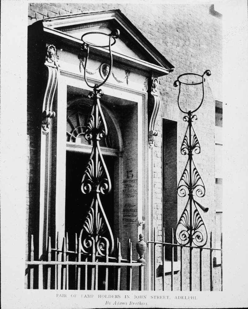 Pair of lamp holders in John Street, Adelphi - wrought iron.